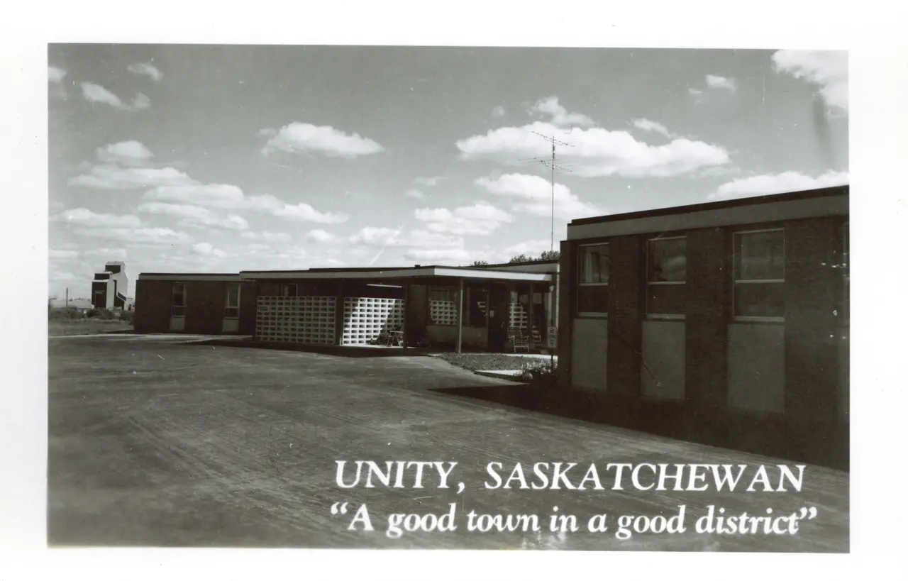 Modern buildings with grain elevator in the distance, Unity, about 1960s